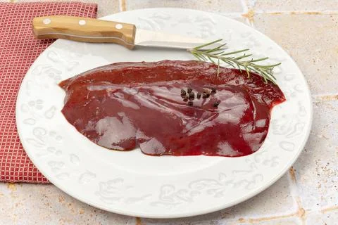 Slice of raw liver in a plate Stock Photos