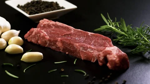 Slice of raw meat, rosmarinus, garlic and black pepper Stockbeeldmateriaal 102609565