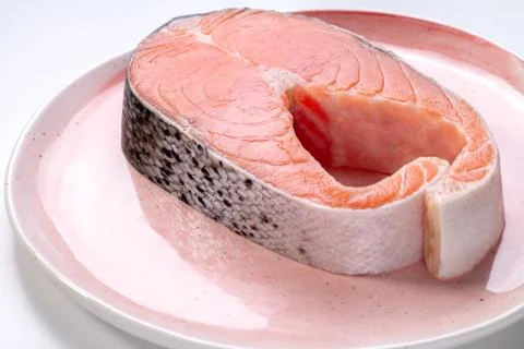 A slice of raw salmon steak on a plate Stock Photos
