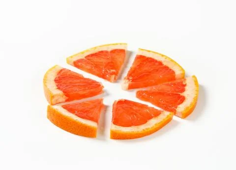 Slice of red grapefruit cut into sixths Stock Photos