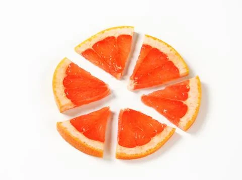 Slice of red grapefruit cut into sixths Stock Photos