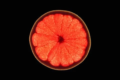 Slice of red grapefruit Slice of ripe ruby grapefruit on black background ... 스톡 사진