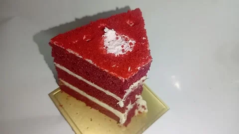 Slice of red velvet cake featuring three layers of deep red sponge cake Stock Footage 337530820