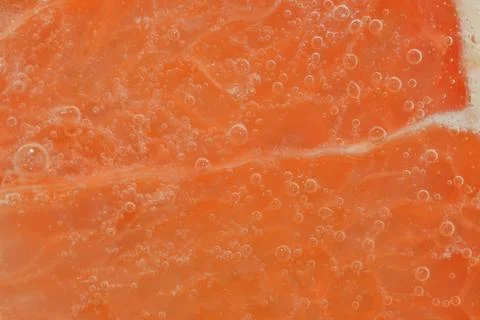 Slice of ripe grapefruit in water. Close-up of grapefruit in liquid with bu.. Stock-Fotos