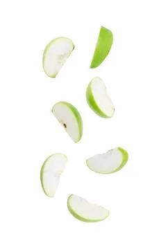 Slice ripe green apple falling isolated on white background with clipping pat Stock Photos