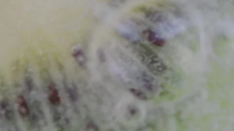 A slice of ripe kiwi in water bubbles. Macro shot of a kiwi slice in sparkling Stock Footage 242425660