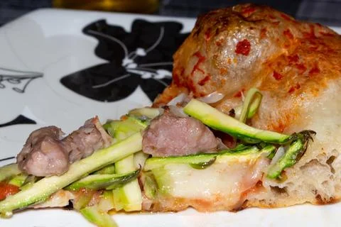 Slice of soft pizza topped with tomato mozzarella, asparagus and sausage Stock Photos