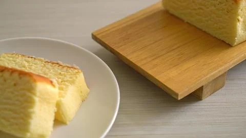 Slice of sponge cake on a white plate with a wooden stand Stock Photos