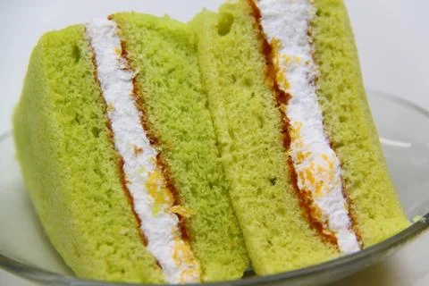 A slice of sponge pandan cake on white background Stock Photos