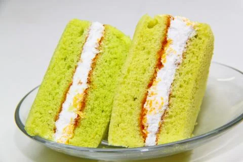 A slice of sponge pandan cake on white background Stock Photos