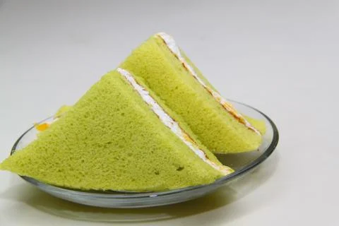 A slice of sponge pandan cake on white background Stock Photos