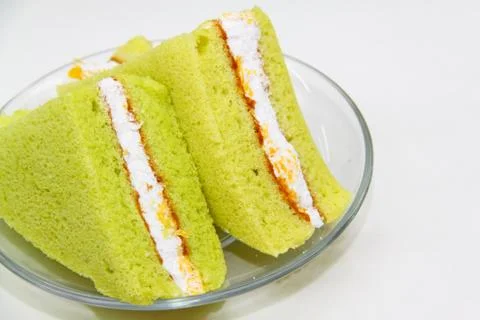 A slice of sponge pandan cake on white background Stock Photos