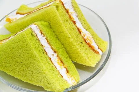 A slice of sponge pandan cake on white background Stock Photos
