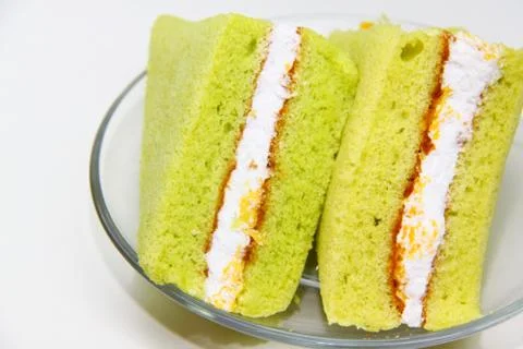 A slice of sponge pandan cake on white background Stock Photos