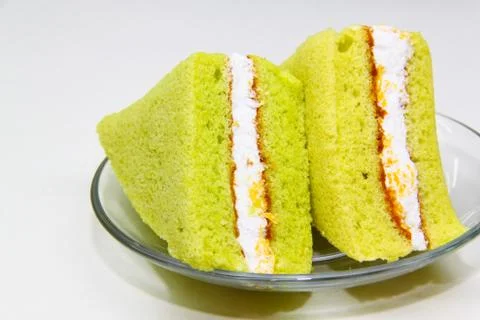 A slice of sponge pandan cake on white background Stock Photos