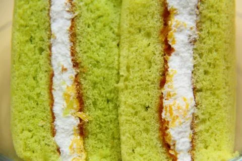 A slice of sponge pandan cake on white background Stock Photos