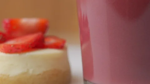 A slice of strawberry cheesecake with a nice raspberry drink in a glass rotates 스톡 동영상 129567710
