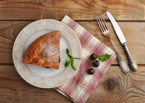 Slice of strudel with cherries on a plate Stock Photos