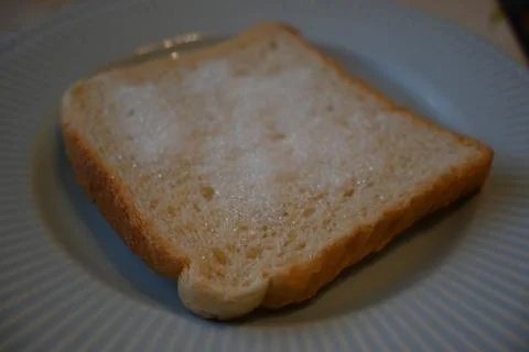 Slice of sugar bread cheap food cost of living concept Stock Photos
