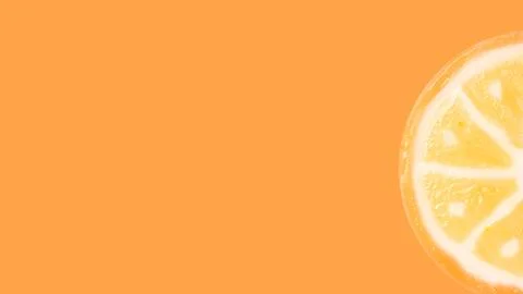 Slice of sugar orange candy on an orange background with copy space. Concept  Stock Photos