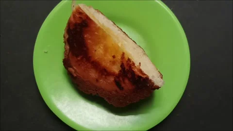 A slice of sweet bread with sweet jam filling is served on a green plate 스톡 동영상 323579687