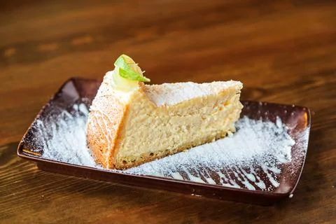 A slice of tender cheesecake with lemon Stock Photos