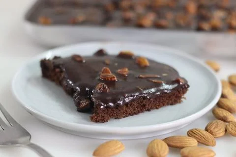 Slice of Texas sheet cake served on a plate. Buttery and chocolaty cake slice 스톡 사진