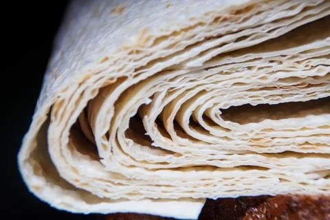 A slice of thin pita bread on a dark background. Stock Photos
