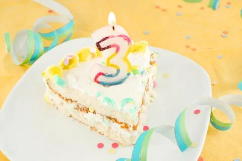 Slice of third birthday cake Stock Photos