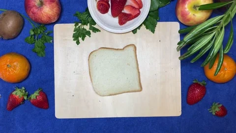 Slice of toast bread rolling on the wooden board surrounded by fruits. Stop Stock Footage 239860984