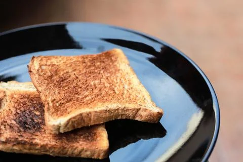 Slice toasted bread on black dish. Stock Photos