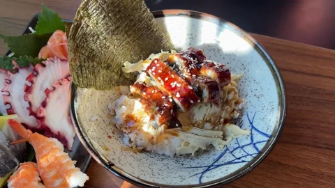 Slice of tuna sashimi from an assorted Japanese sushi platter with salmon Stock Footage 317698521