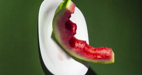 Slice of watermelon bite on green background. Vertically oriented Stop motion Stock Footage 138632951