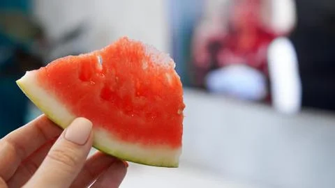 Slice of watermelon in hand on a blurred background Stock Photos
