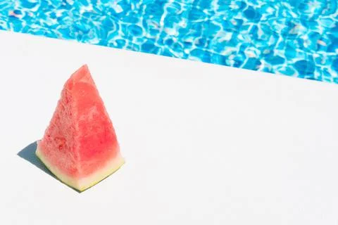 A slice of watermelon by the pool. concept of summer, holidays and food Stock Photos
