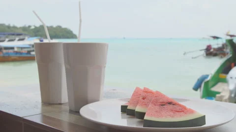 Slice of watermelon on the table on the seafront Stock-Footage 68736120