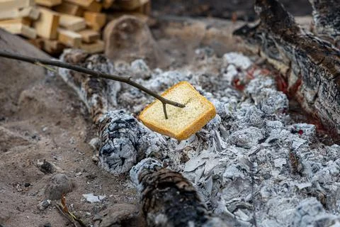 The Slice of white bread and Gray big stones and trunks for a bonfire are in Stock Photos