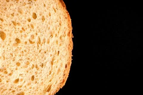Slice of white bread close up isolated on a black background. rough dappled t Stock Photos