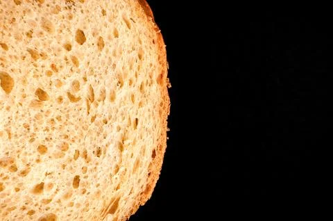 Slice of white bread close up isolated on a black background. rough dappled.. Foto stock