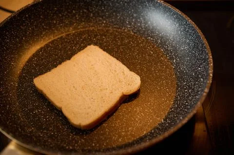 Slice of White Bread Sizzling in a Frying Pan for a Simple Breakfast Stock Photos