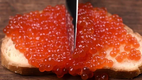 Slice of white bread smeared with red caviar Stock Footage 146325414