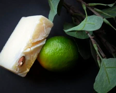 Slice of white handmade soap and fresh green lime Stock Photos
