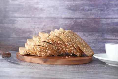 Slice of whole grain bread on chopping board Foto stock
