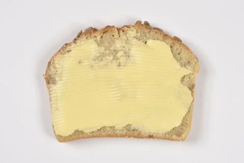 Slice of whole grain bread with spread butter Stock Photos