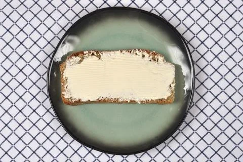 Slice of whole grain bread with spread on a plate Stockfoto's