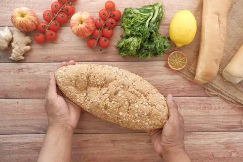 Slice of whole meal bread and fresh vegetables on table Foto stock