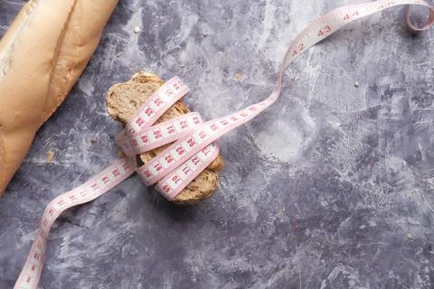 Slice of whole meal bread and measurement tape on table . Foto stock