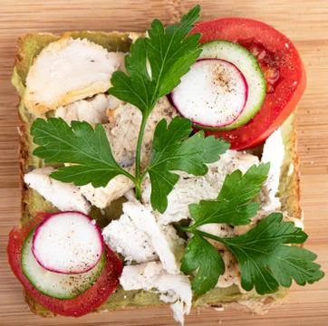 Slice whole wheat bread, avocado paste and grilled chicken breast, garnished Stock Photos