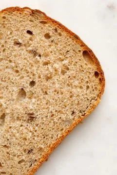 Slice of a whole wheat bread on a marble tray. Healthy Hand Made Bread. Mac.. Stock Photos