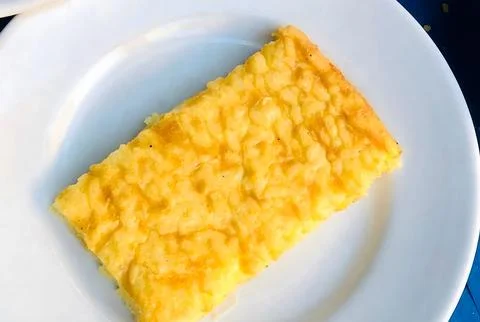 A slice of yellow cake on a white plate. Stock-Fotos